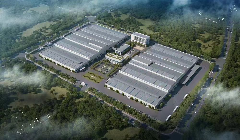 Bird's-eye view of a factory campus with two large workshop buildings, an office block and surrounding trees, as published by the manufacturer