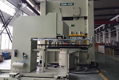A large light grey press marked D2N-400 on a workshop floor with material stacked beside it